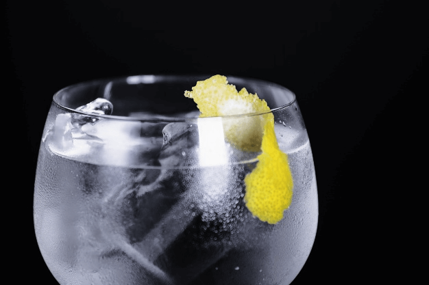taça de gin com aparência refrescante em plano de fundo com tela preta.