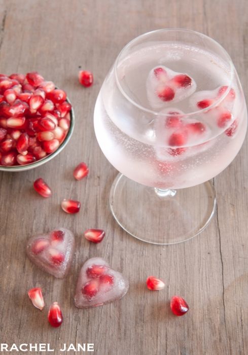 uma taça de água gaseificada com gelos saborizados de frutas vermelhas em formato de pequenos corações