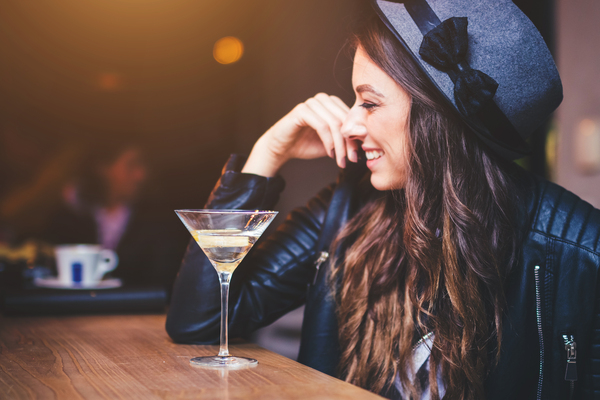 mulher sentada em um bar em frente a um cocktail