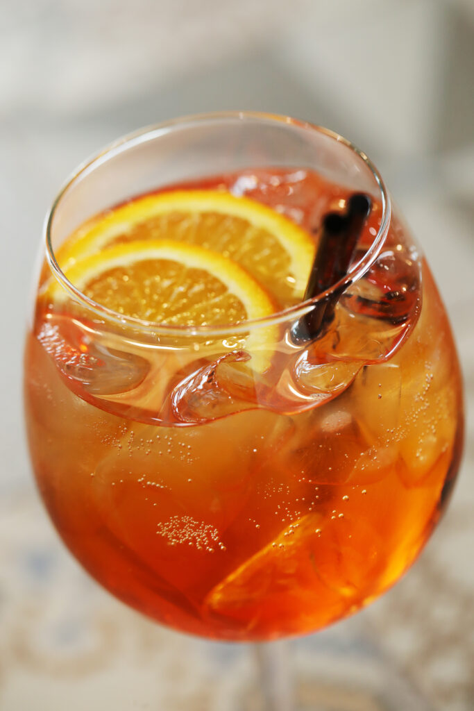 Gin tropical: taça de drink com gin e rodelas de laranja.